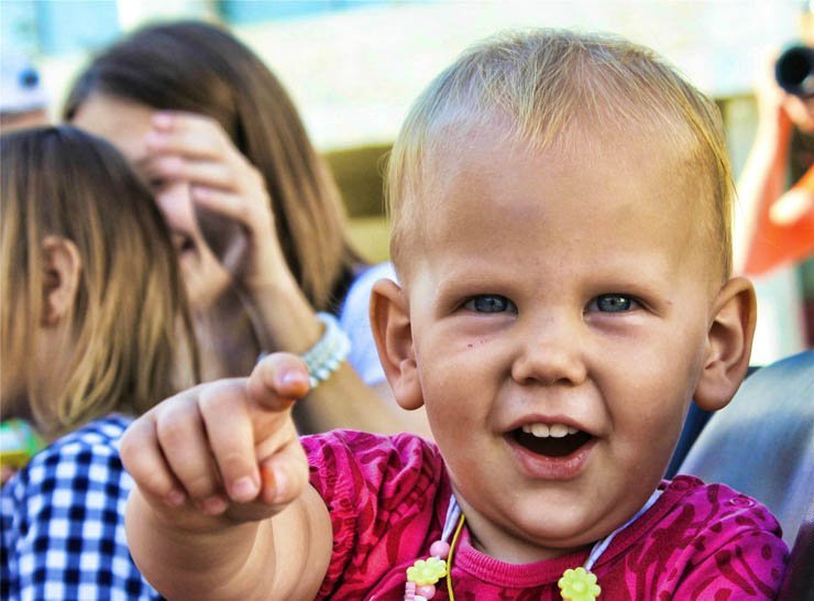 baby pointing smiling crowd
