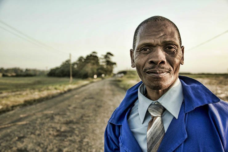 old man blue jacket tie outdoor african