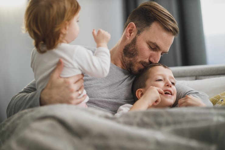 love care family mom dad father mother happily happiness son daughter kid kids child children summer outdoor kiss bedroom bed